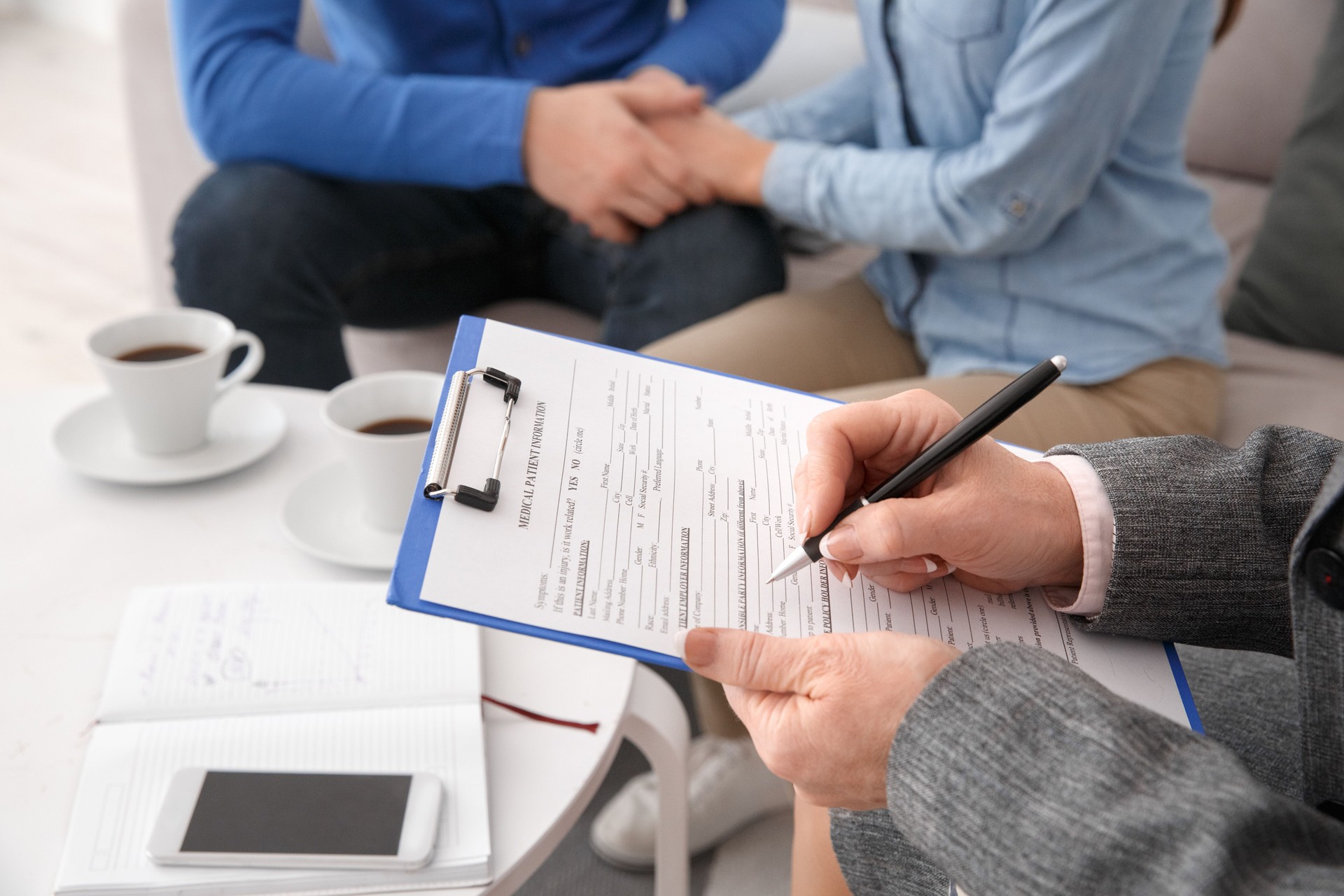 Young couple with psychologist family therapy therapist fulfilling medical form